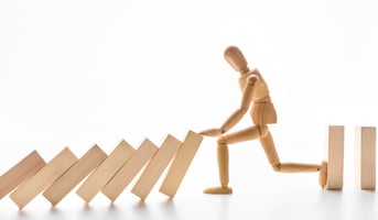 Wooden mannequin stopping domino effect