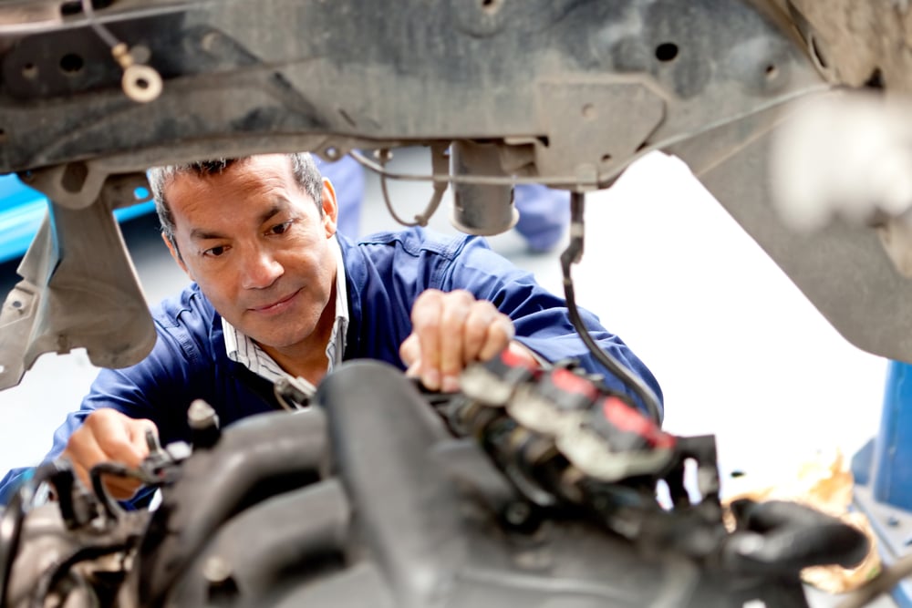 Mechanic fixing an engine of a car at the garage